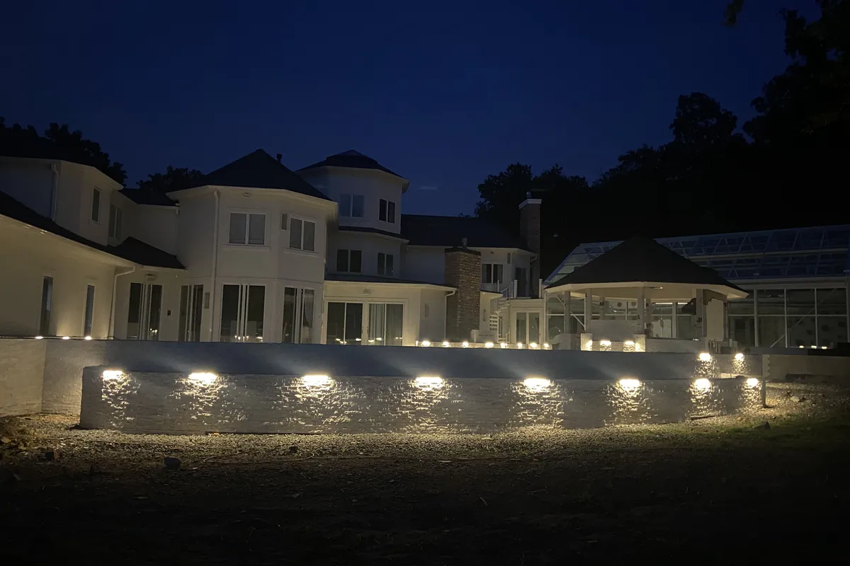 PTB Landscape Management outdoor living space with illuminated landscape lighting at night