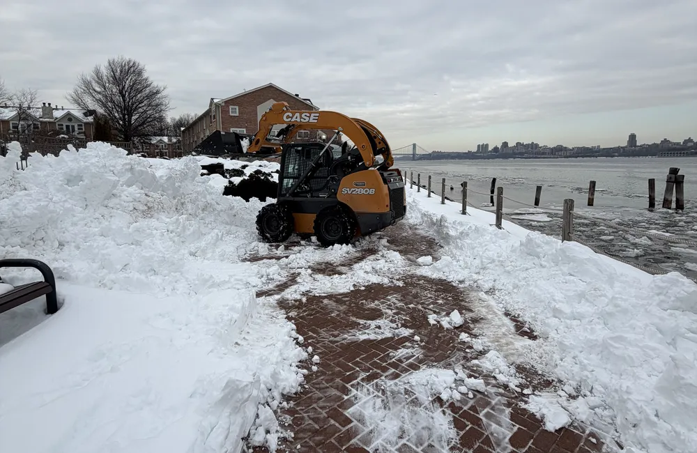 PTB skid steer plowing snow at a commercial waterfront property